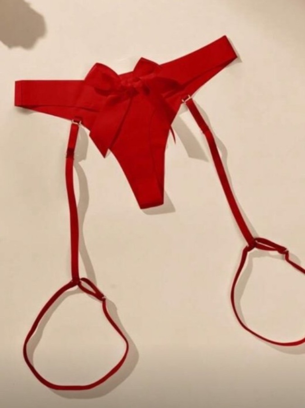 Bold red satin thong with a decorative front bow w garter straps